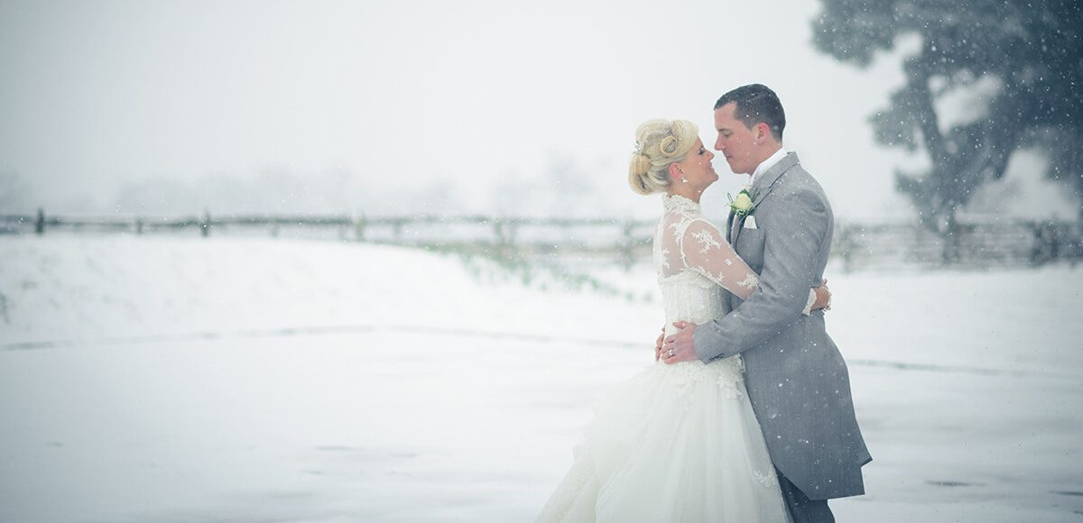 The bride and groom share an embrace in the stunning Walled Garden covered with a blanket of snow