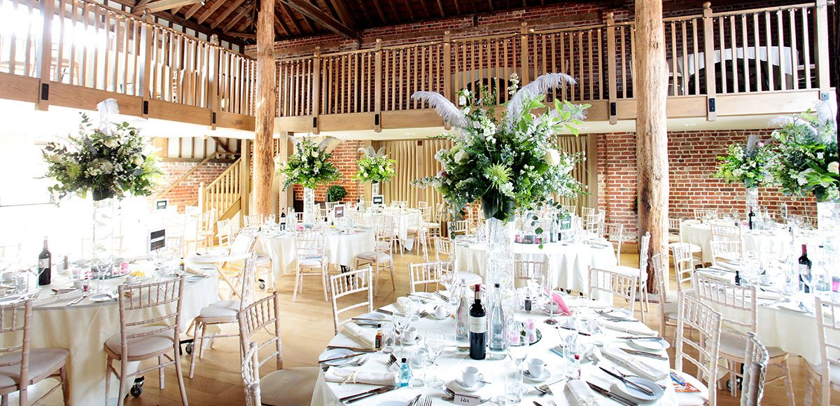 Tall flower vases as wedding centrepieces for an Essex barn wedding
