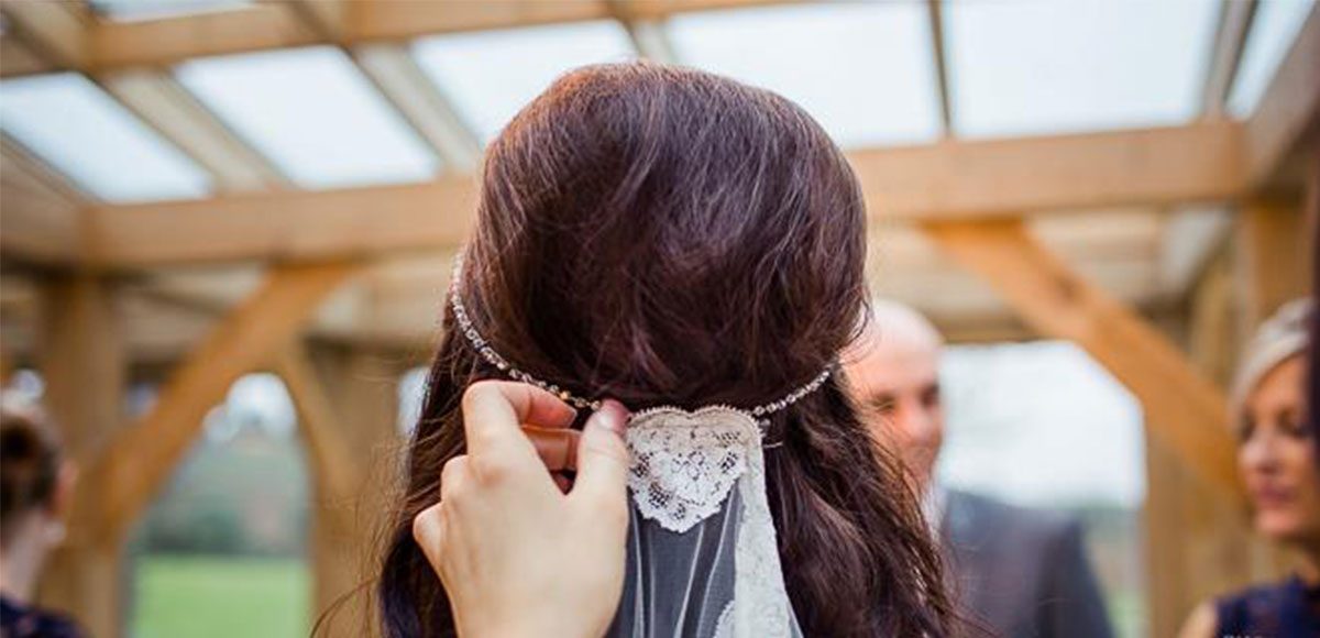 Close up of bride’s lace veil during her barn wedding ceremony