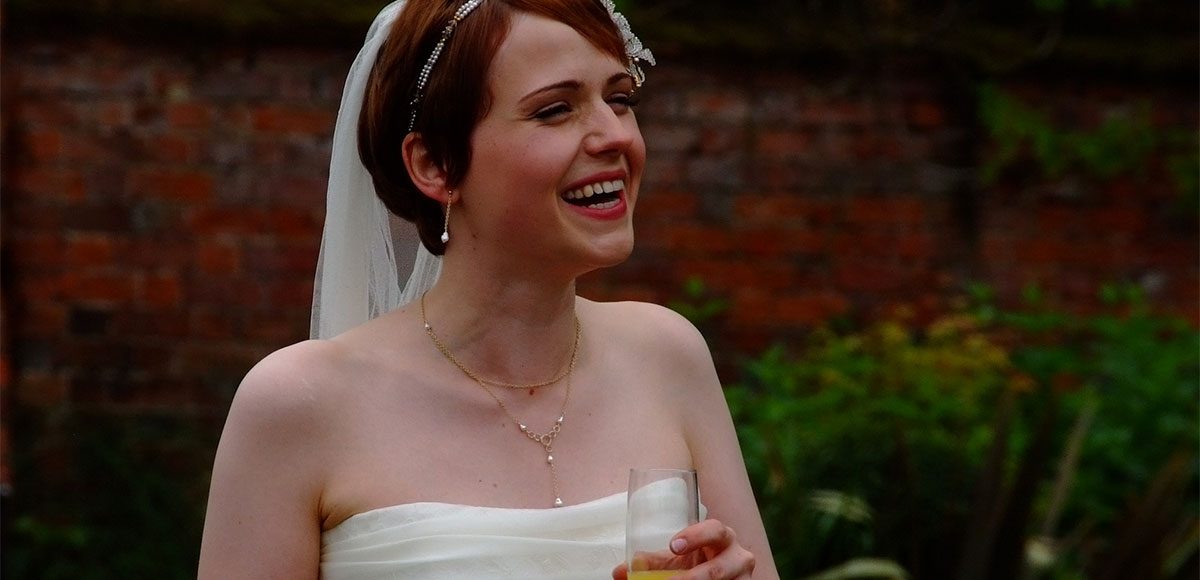 Bride smiling enjoying the wedding reception at Gaynes Park