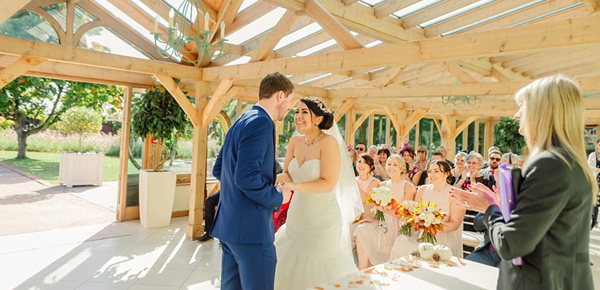 The bride and groom say their vows in the orangery at Gaynes Park
