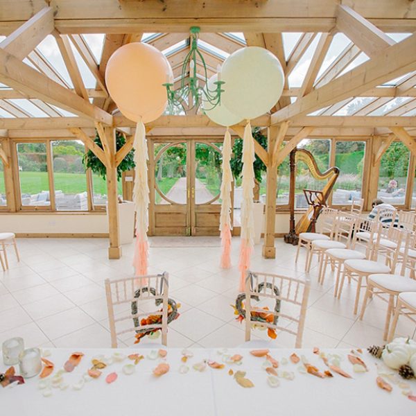 The Orangery at Gaynes Park decorated with blush coloured oversized wedding balloons