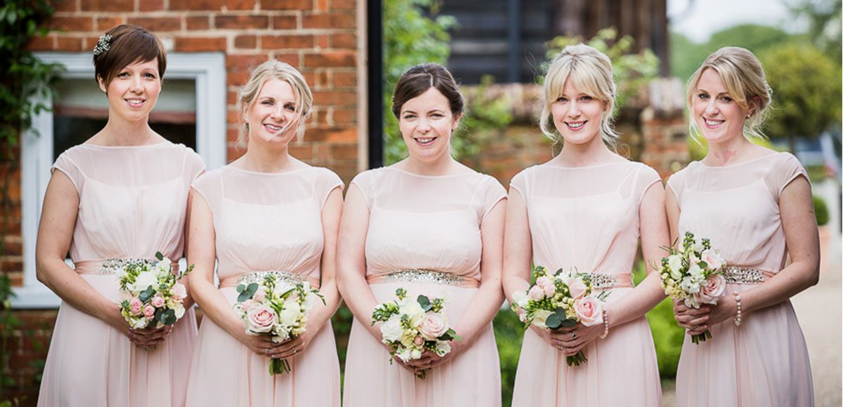 Bridesmaids with peachy pink dresses for a Gaynes Park wedding