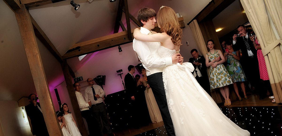 The bride and groom take to the dancefloor for their first dance together in front of their wedding guests