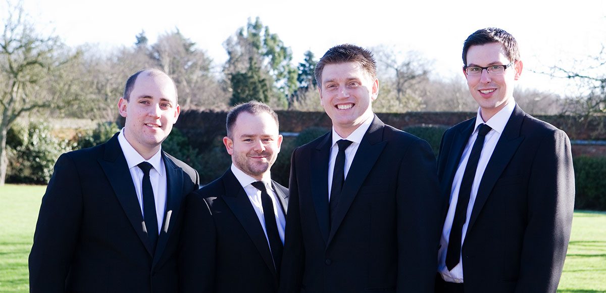 Groomsmen posing for a photo in the gardens