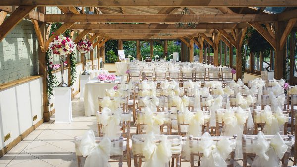The Orangery is decorated with white ribbons and pink flowers ready for a wedding ceremony