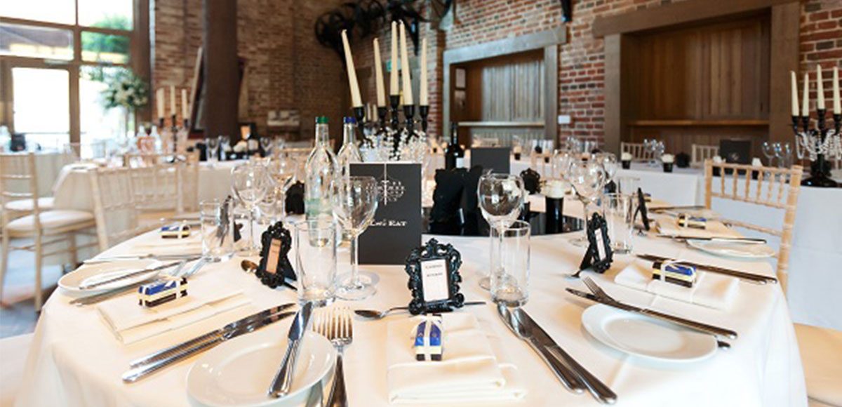 Black and white table decorations set out in the Mill Barn – barn weddings Essex