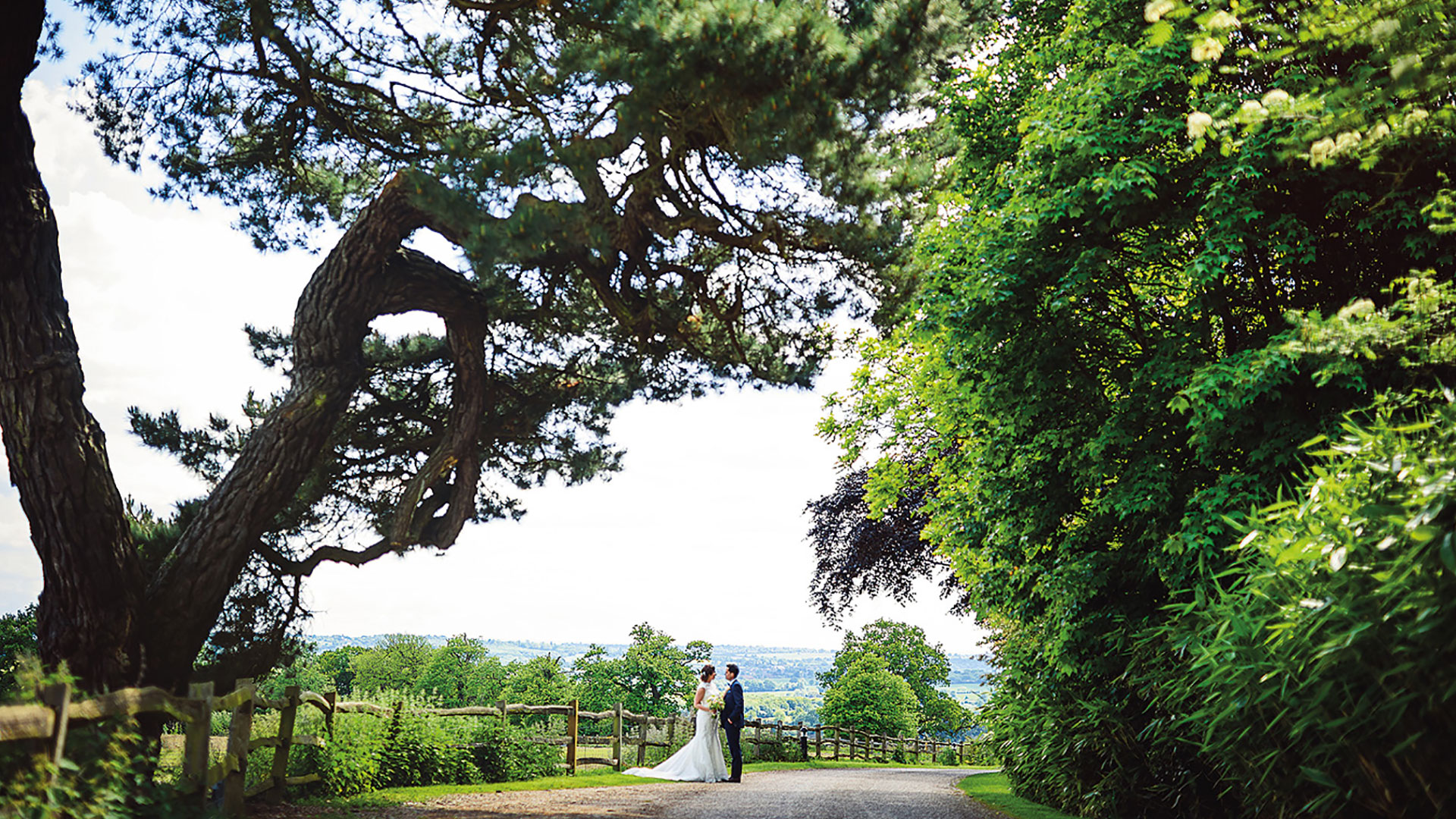 A couple steal a moment away on the entrance drive of this exquisite countryside wedding venue in Essex