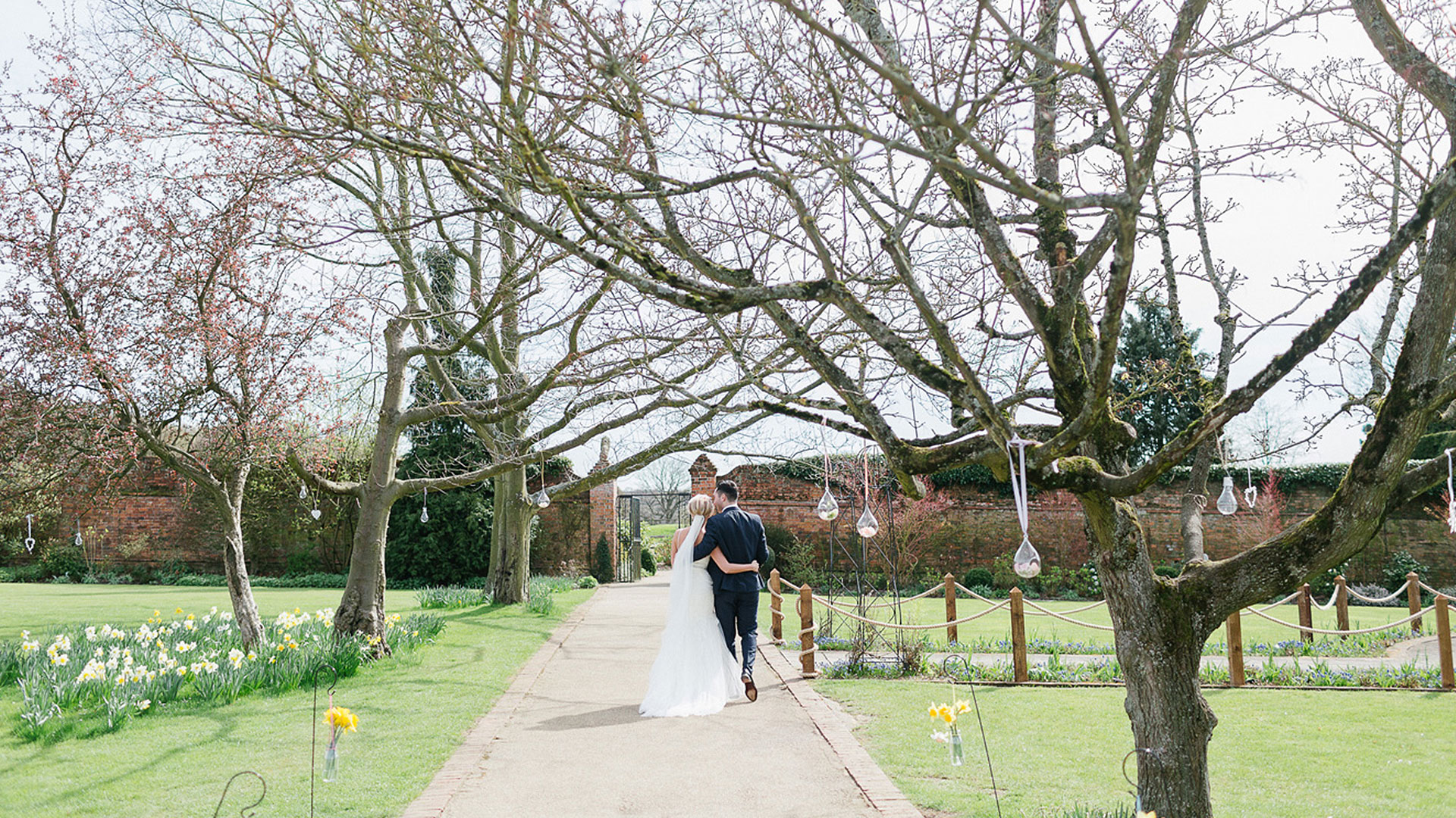 A bride and groom steal a moment in the Walled Garden which has year-round colour - garden weddings