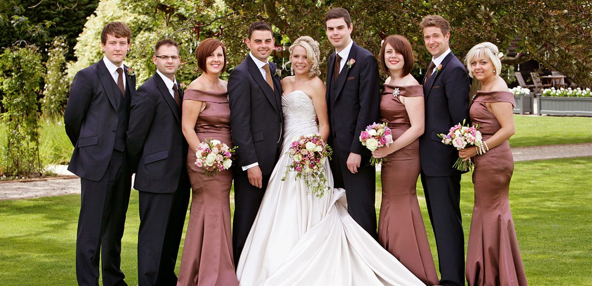 Bride and groom with their bridesmaids and groomsmen in the gardens – Essex wedding venues
