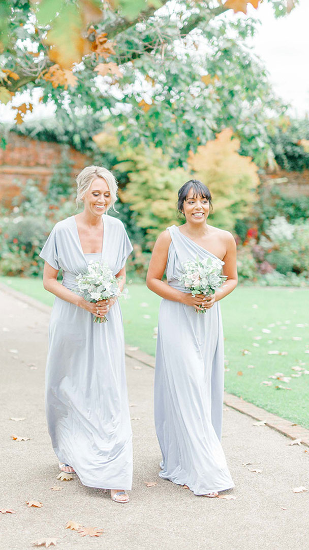 Bridesmaids wear pale blue bridesmaid dresses for their walk down the aisle and to the wedding ceremony barn