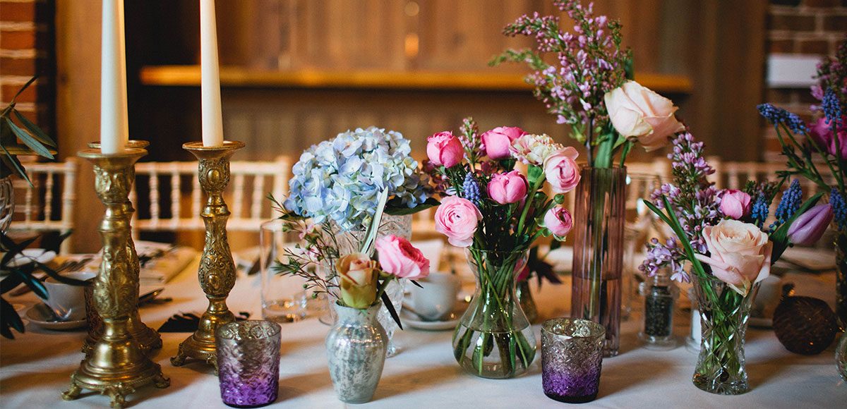 Colourful flowers as table decorations for a barn wedding in Essex