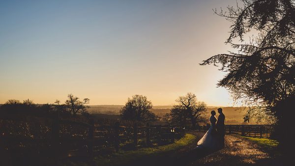 A bride and groom stand on the wedding entrance drive of this barn wedding venue - wedding photo ideas