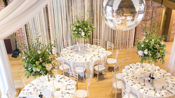 A disco ball hangs from the ceiling in this Essex barn wedding venue - wedding ideas