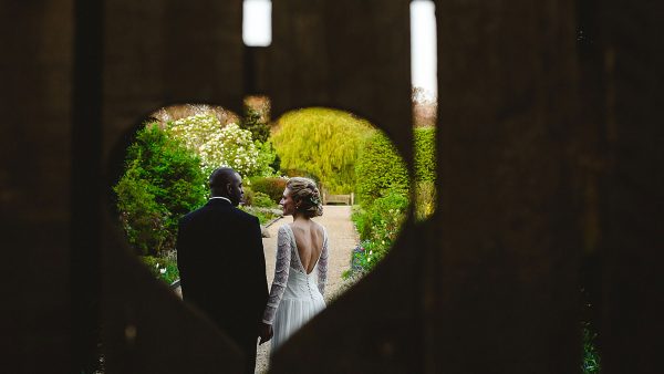 A bride and groom steal a moment behind the heart gate - wedding photos