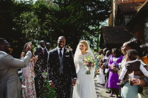 Guests throw confetti at a happy couple after their church wedding in Essex