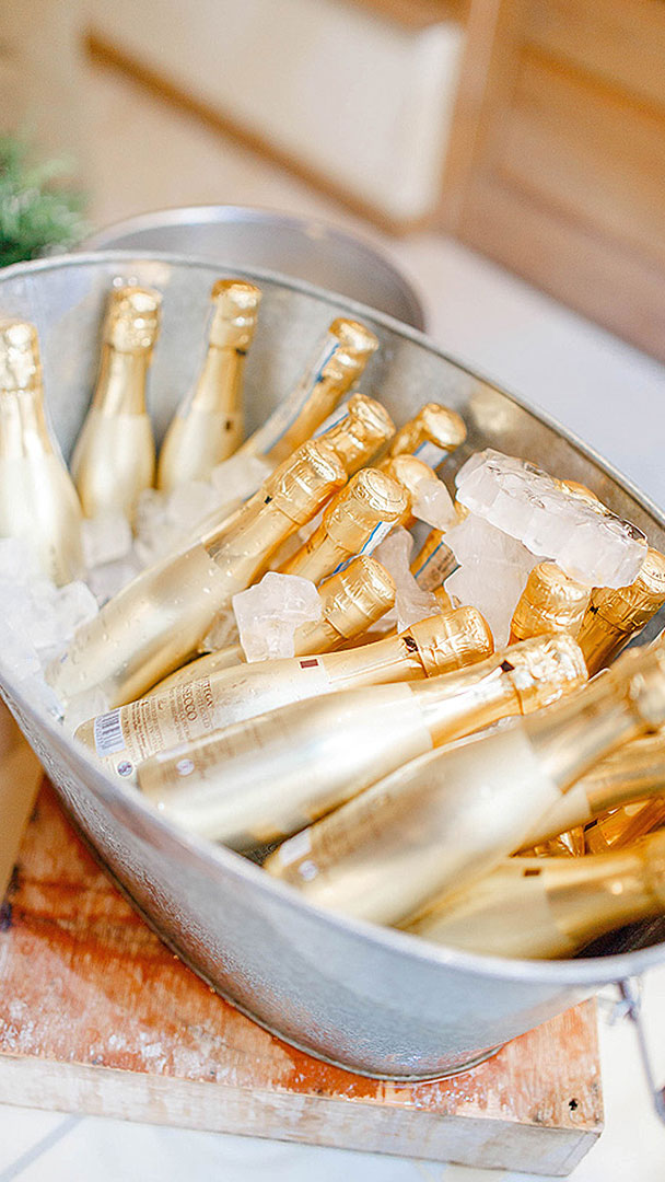 Treat guests to small champagne bottles presented in a rustic metal container - wedding drink ideas
