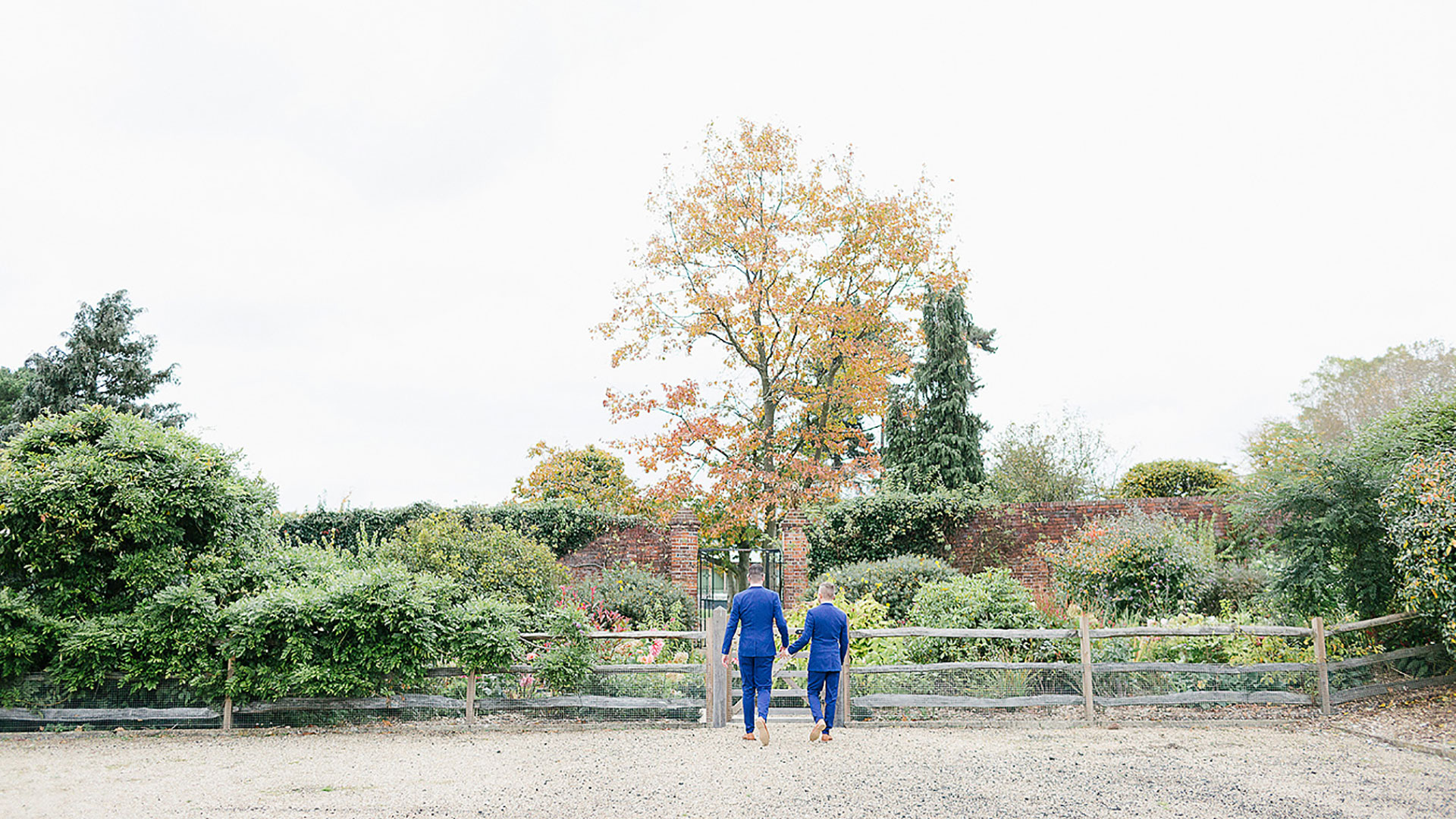 A happy couple make their way to the Long Walk wedding aisle lined with colourful flowers