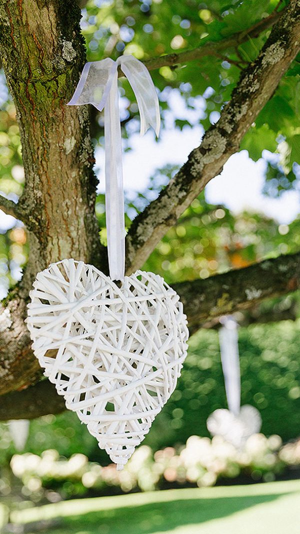 White wicker wedding hearts hung from trees add a pretty touch to your garden wedding - wedding ideas
