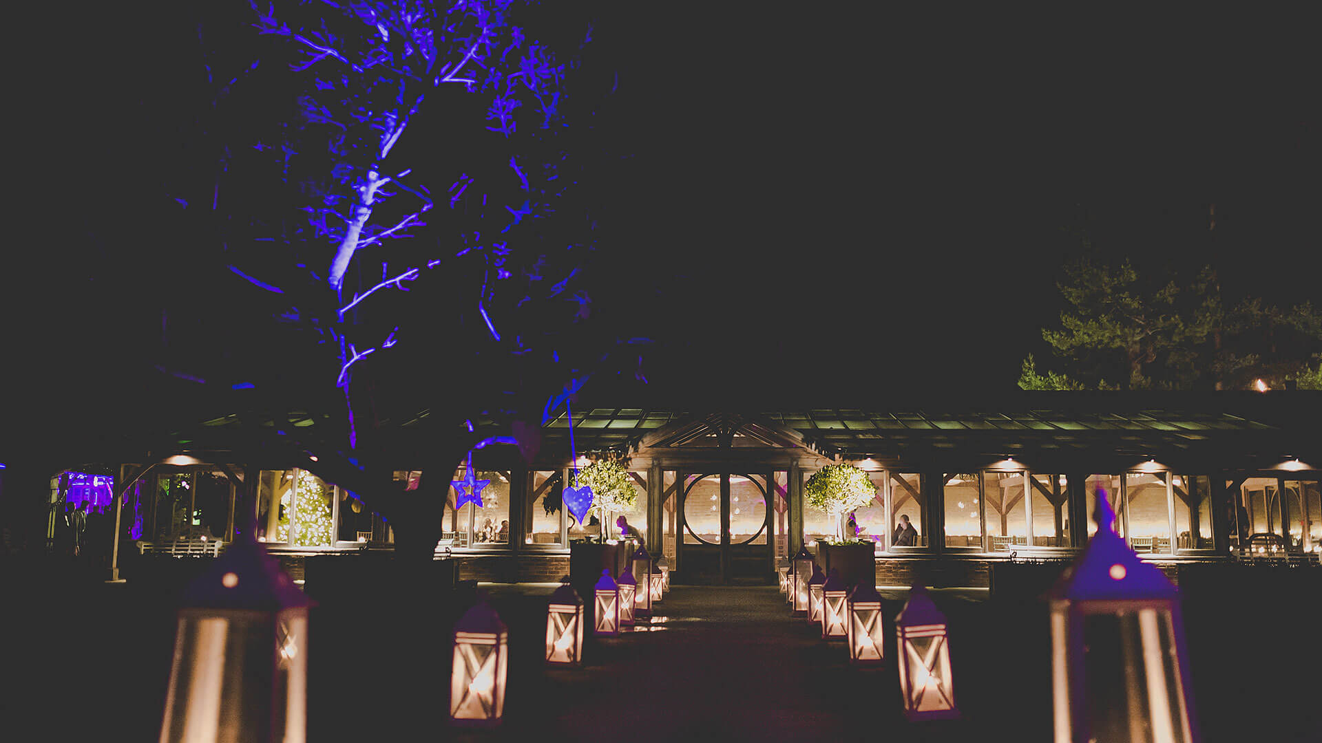 The Long Walk outdoor wedding aisle is lined with lanterns at night - romantic wedding venues in Essex