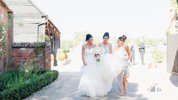A bride and her bridesmaids make their way from the Gather Barn for more wedding photos