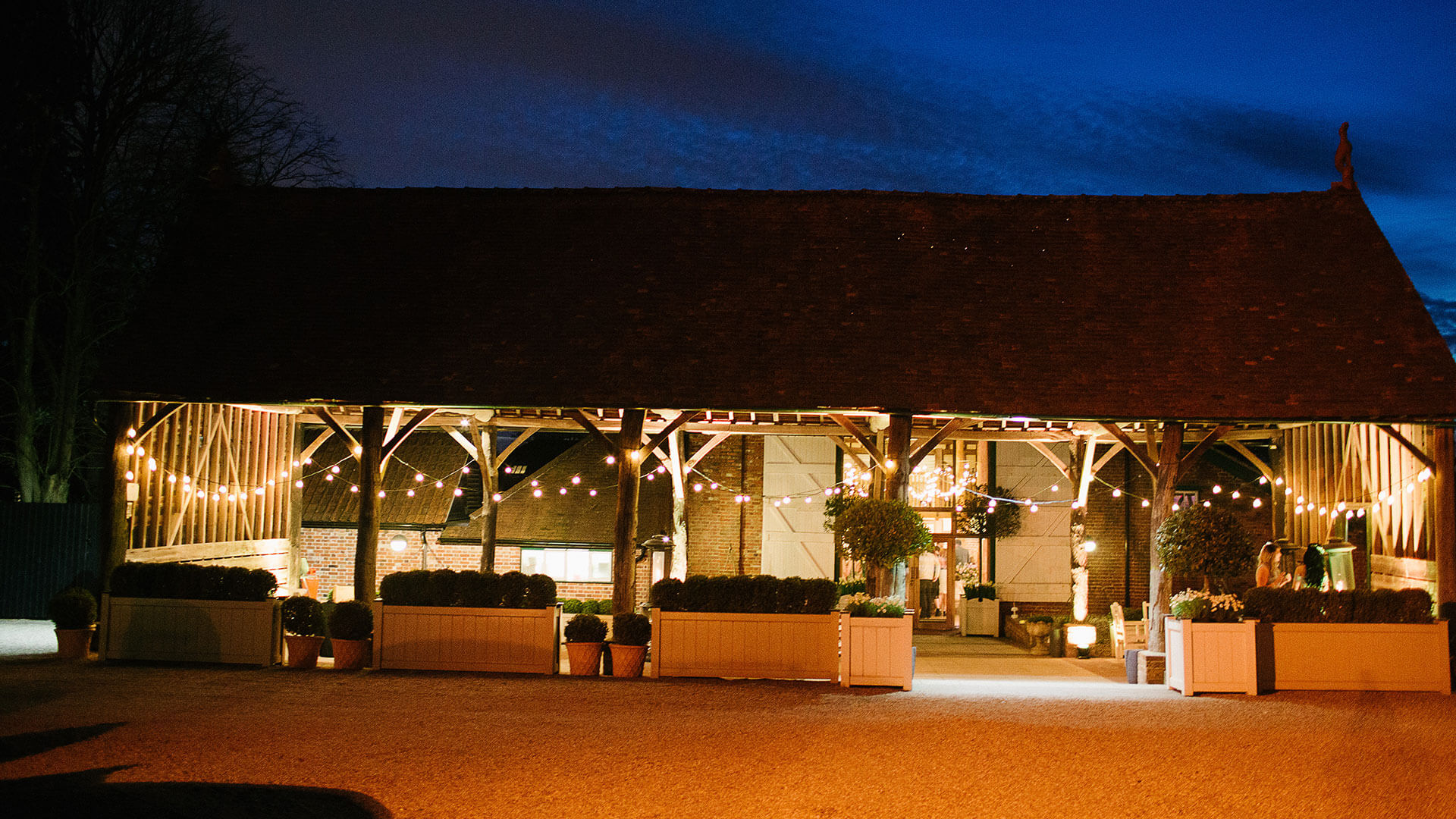 The Gather Barn looks romantic at night lit up with festoon lighting - barn wedding ideas