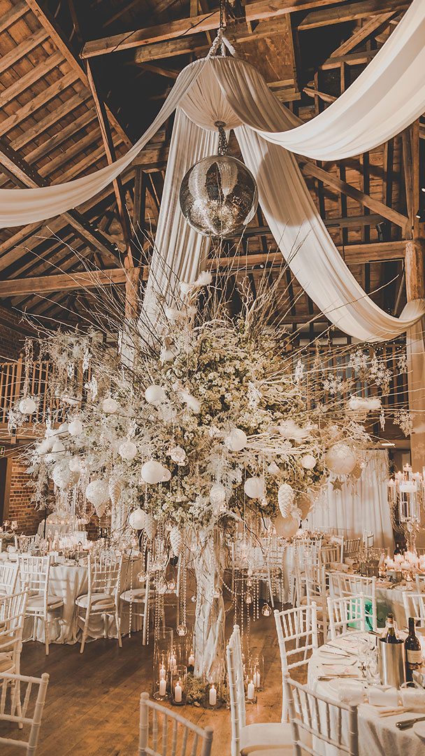 A huge centrepiece of branches baubles and candles creates a wow factor at this winter wedding