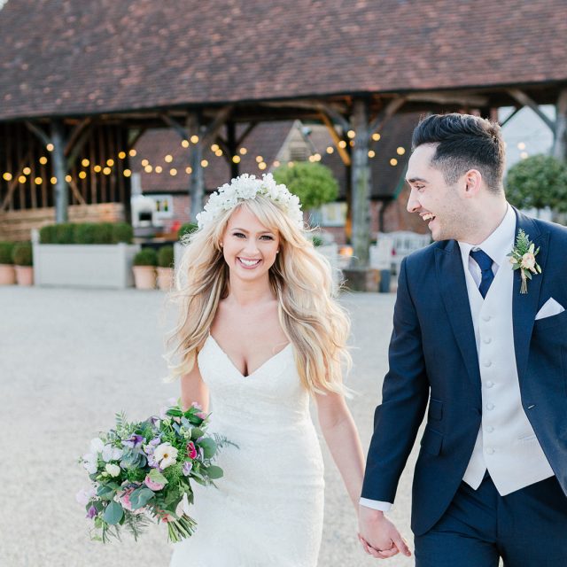 Bride and groom hand in hand enjoying their wedding at Gaynes Park