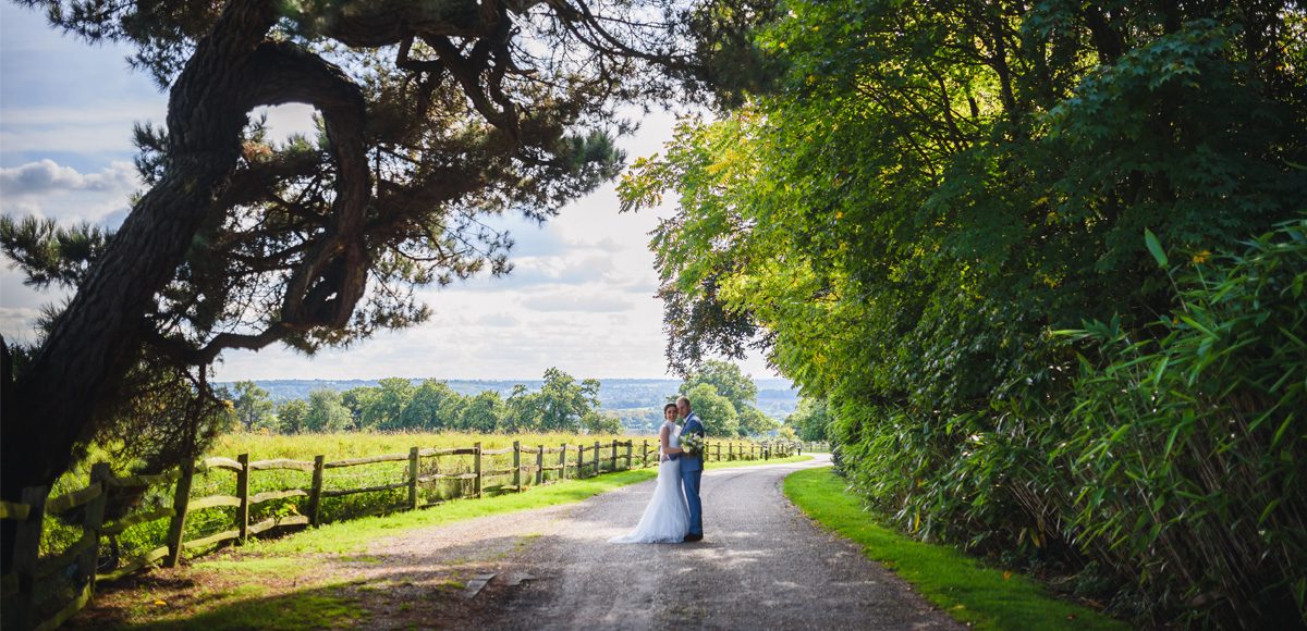 Bride and groom use the countryside views at Gaynes Park to take their wedding photos