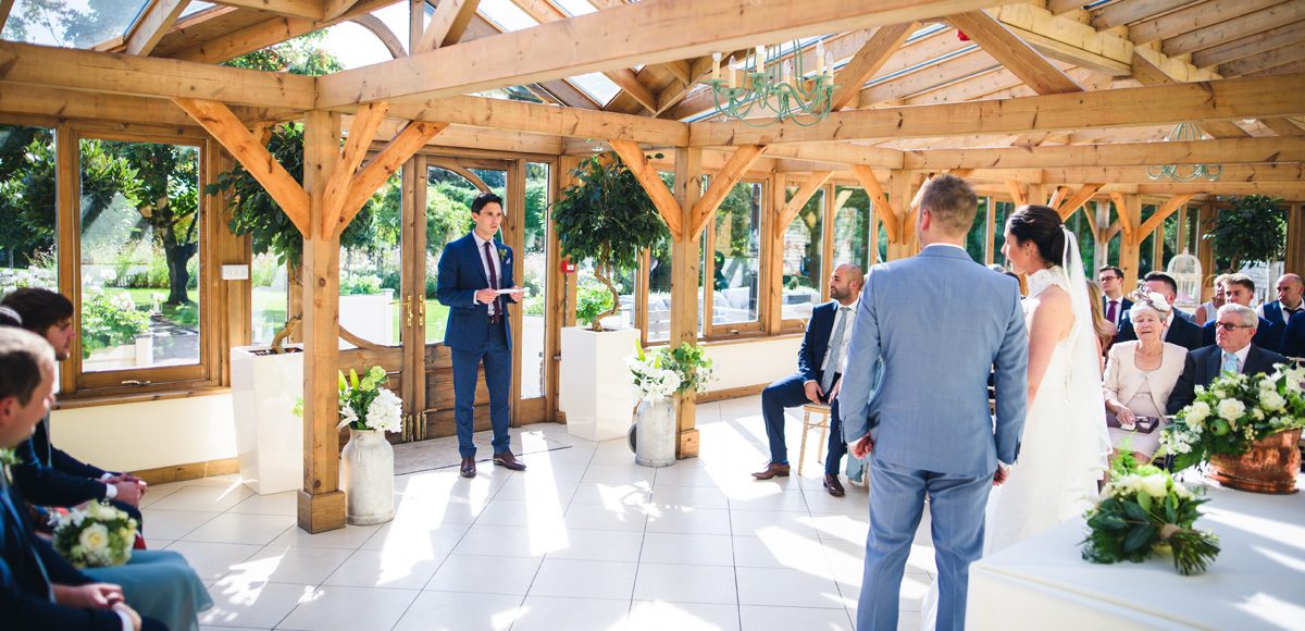 Groomsmen performing a reading to bride and groom during their ceremony at Gaynes Park
