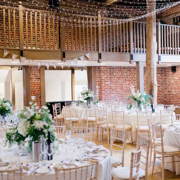 Wedding reception tables set up inside the Mill Barn at Gaynes Park – barn venue hire