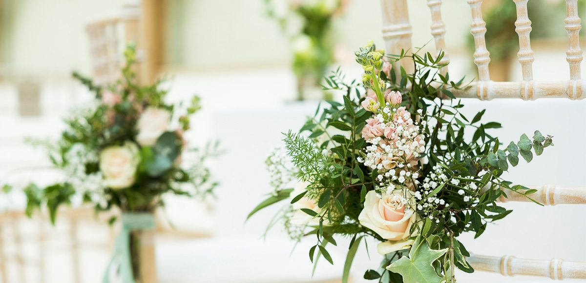 Small bunches of flowers tied to the ceremony chairs
