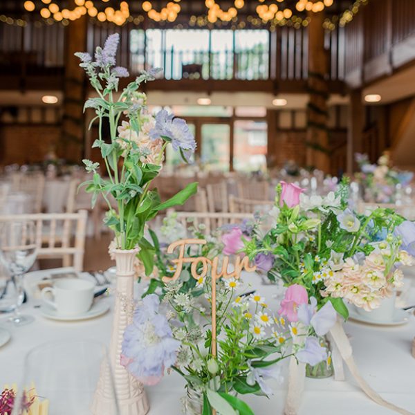 A table is decorated with wedding flowers including daisies, which are perfect for a spring wedding