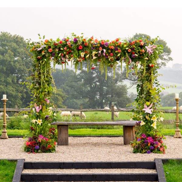 A stunning floral arch stands in the grounds of the beautiful Essex wedding venue and creates a wow factor