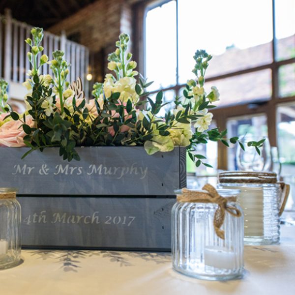 Personalised blue apple crates were filled with flowers to create natural spring wedding table centrepieces