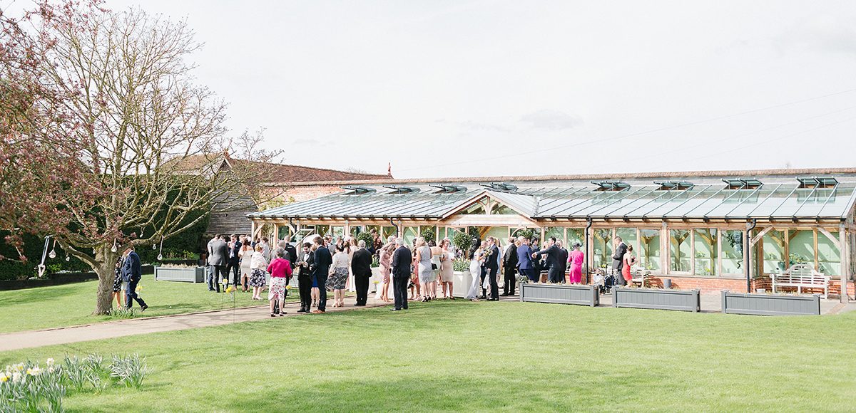 Wedding guests gathered outside the Orangery at Gaynes Park in Essex for the wedding drinks reception