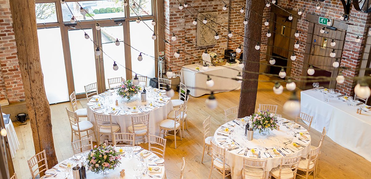 The Mill Barn at Gaynes Park is decorated with bright spring blooms for the spring wedding reception
