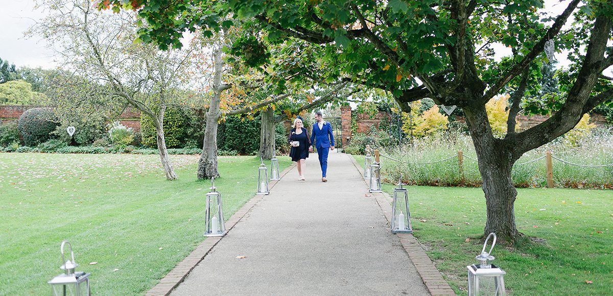 The groom and his mum walk down the Long Walk at Gaynes Park towards the wedding ceremony