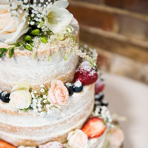 A naked wedding cake adds a rustic look to a vintage wedding at Gaynes Park