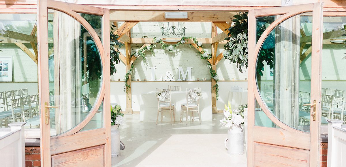 The entrance to the Orangery at the Essex wedding venue looked stunning decorated with white wedding flowers