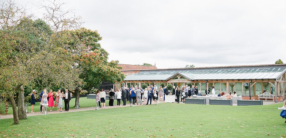 Wedding guests enjoyed wedding reception drinks outside the Orangery at Gaynes Park in Essex