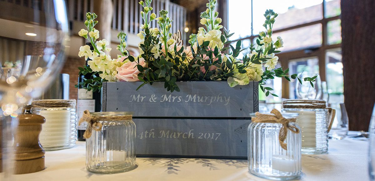 Wedding flowers are surrounded by glass jars for a stunning vintage wedding table centerpiece