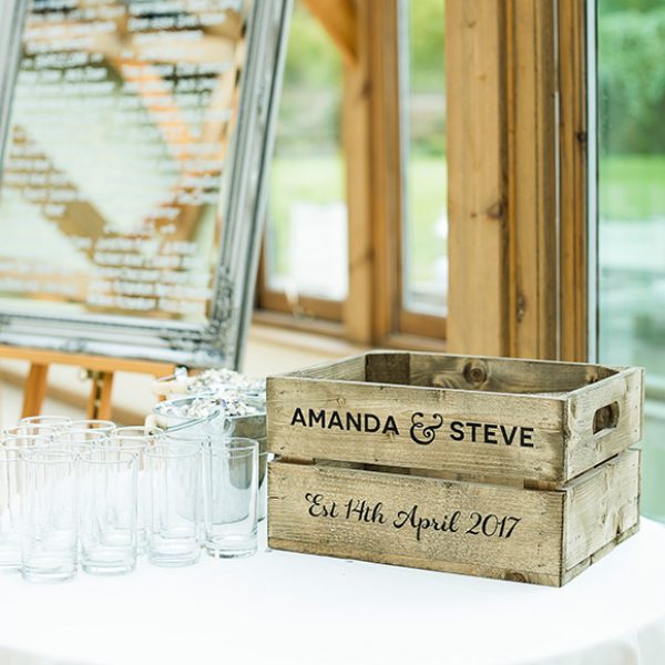 A vintage apple crate is personalized with the bride and grooms names for a wedding at Gaynes Park