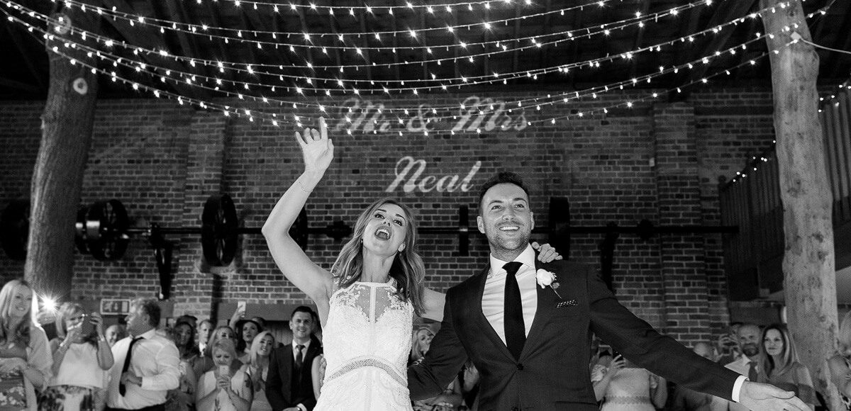 A couple celebrate with their name in lights during their evening reception at Gaynes Park in Essex