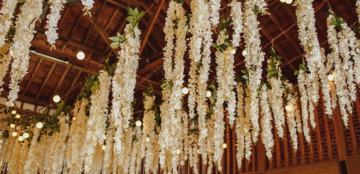 The bride hung wisteria in the Mill Barn at Gaynes Park for a magical touch to her woodland themed summer wedding