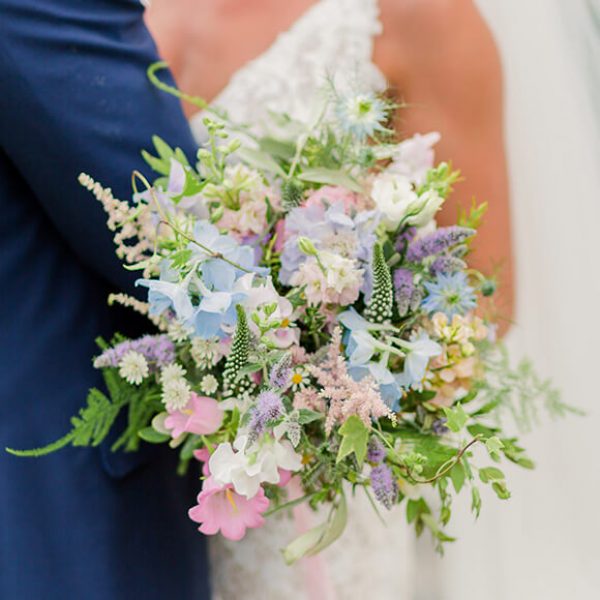 A beautiful spring wedding bouquet adds a pop of colour to a wedding at Gaynes Park wedding venue in Essex