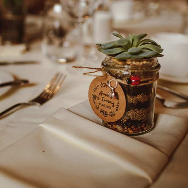 A couple gave guests succulents in jam jars as a rustic wedding favour for their Gaynes Park wedding