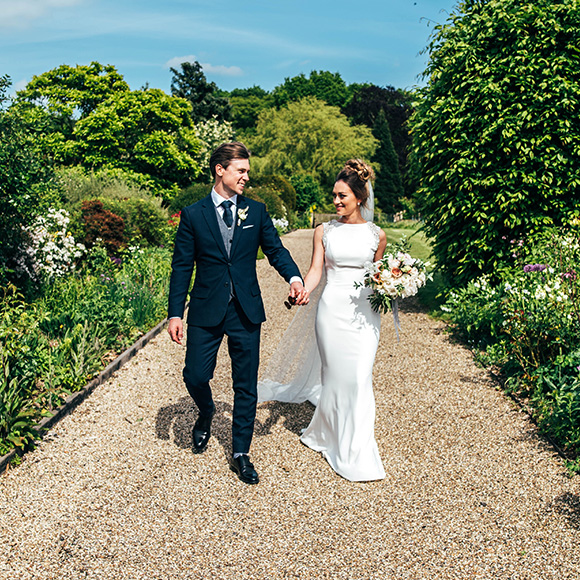 The newlyweds take a stroll down the Long Walk at Gaynes Park after their wedding ceremony