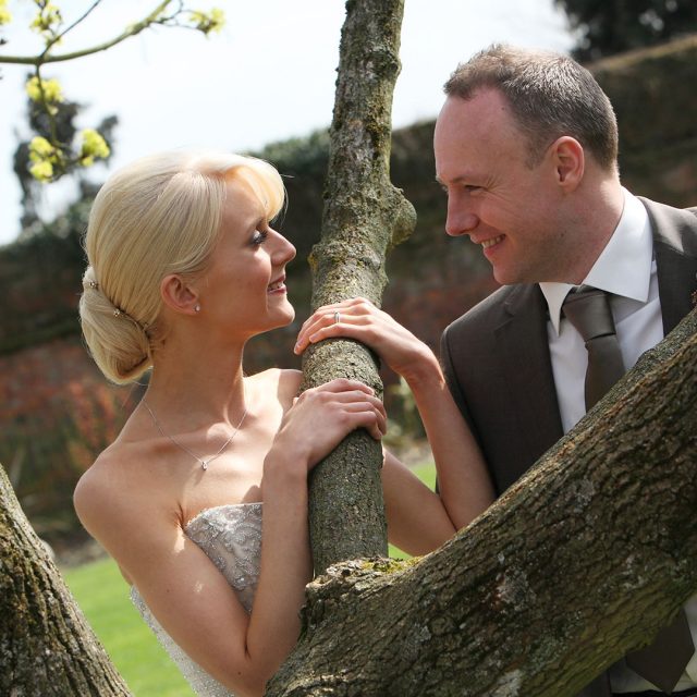 Bride and groom posing in the gardens of Gaynes Park in Essex