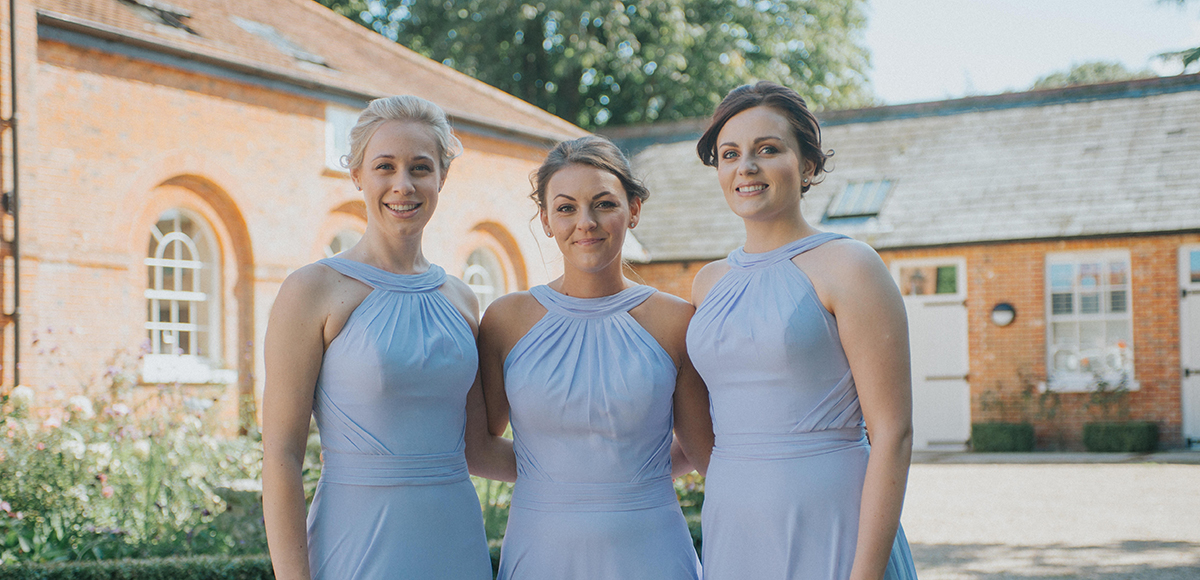 Three bridesmaids wear lilac bridesmaid dresses for a late summer wedding at Gaynes Park